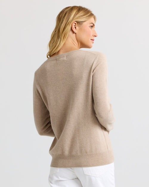 LIFESTYLE / EDITORIAL: Woman wearing a cappuccino-colored cashmere sweater, viewed from the back, paired with white pants