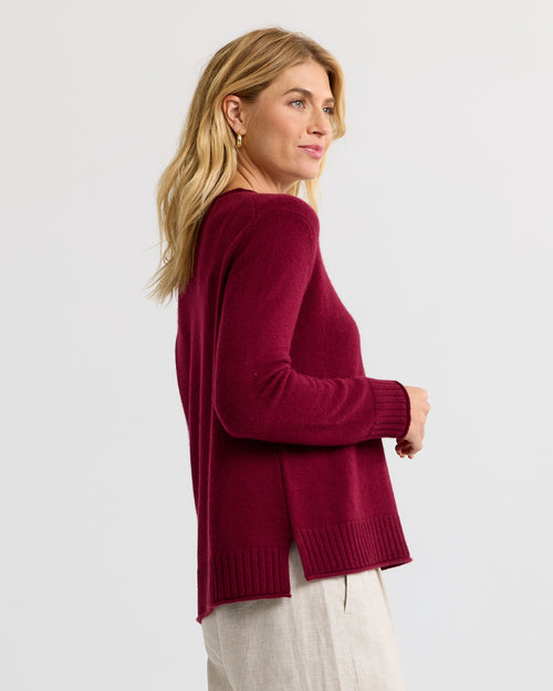 Woman in side profile wearing a long-sleeve barolo red cashmere sweater with ribbed cuffs and hem