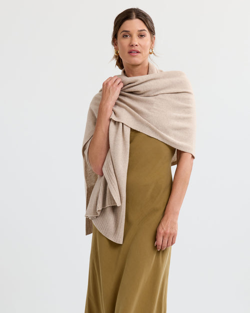 LIFESTYLE / EDITORIAL: Woman wearing olive dress with cappuccino-colored cashmere shawl draped over shoulders against white