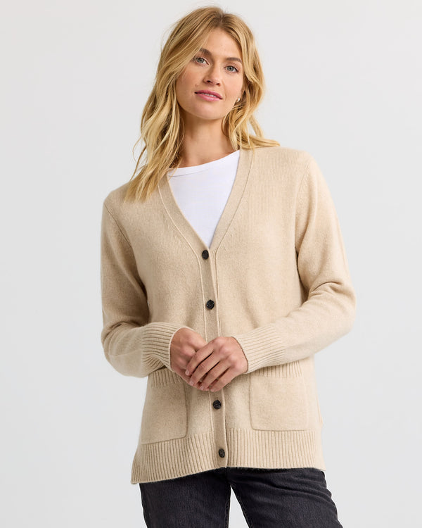 LIFESTYLE / EDITORIAL: Woman wearing sandstone beige cashmere cardigan over white top and black pants against white