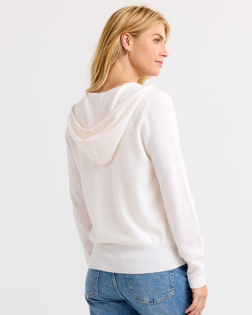LIFESTYLE / EDITORIAL: Woman wearing ivory cashmere hoodie sweater and blue jeans, shown from back and side profile