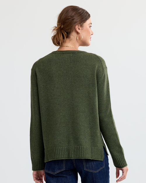 Back view image of a woman wearing a Loden cashmere sweater in olive green, standing against a plain background.