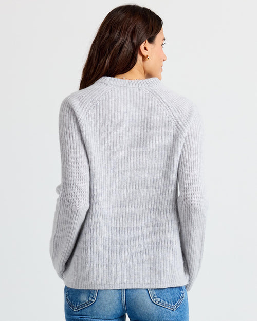 LIFESTYLE / EDITORIAL: Woman wearing light gray ribbed cashmere sweater, back view, paired with blue jeans
