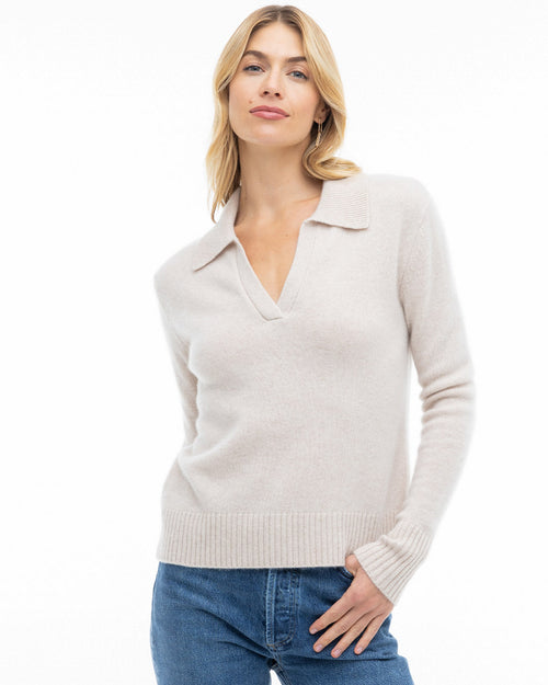 Front view image of a woman wearing an oatmeal cashmere sweater with collar and V-neck, paired with blue jeans, shot 5.