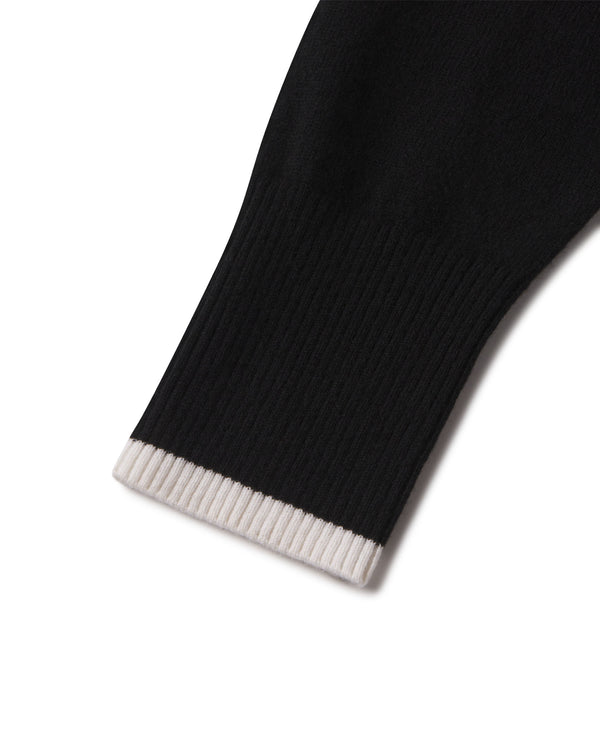 Close-up of black cashmere sleeve cuff with ivory ribbed edge on a hoodie