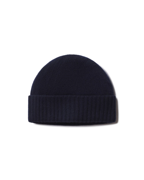 Cashmere knit navy blue beanie hat with folded ribbed cuff, isolated on white background