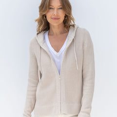 LIFESTYLE / EDITORIAL: Woman wearing beige zip-up cashmere hoodie over white V-neck shirt against white background