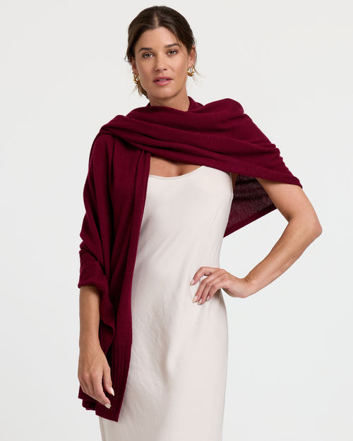 LIFESTYLE / EDITORIAL: Woman wearing a white dress with a burgundy cashmere shawl draped over her shoulders