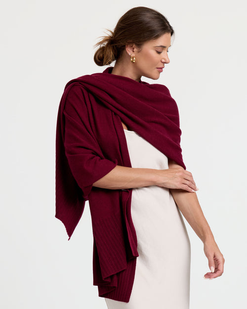 LIFESTYLE / EDITORIAL: Woman wearing a white dress with a barolo-colored cashmere shawl draped over her shoulders