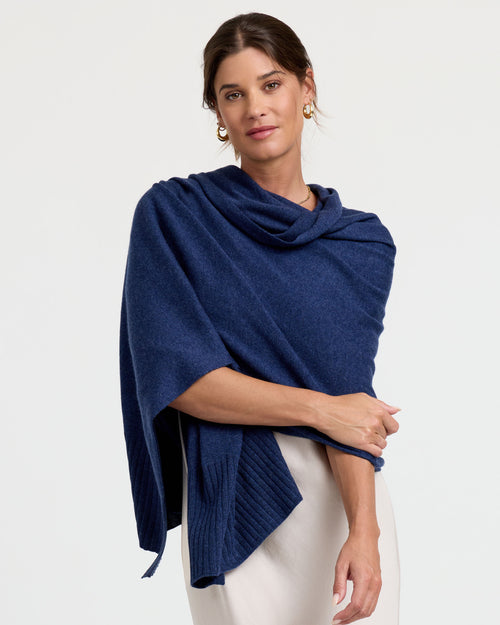 Woman wearing indigo cashmere wrap draped over shoulders against plain background