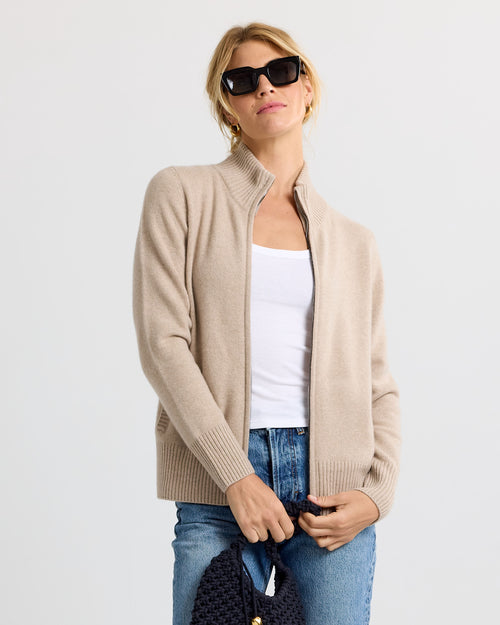 LIFESTYLE / EDITORIAL: Woman wearing cappuccino cashmere zip-up sweater, white tank top, blue jeans, and black sunglasses