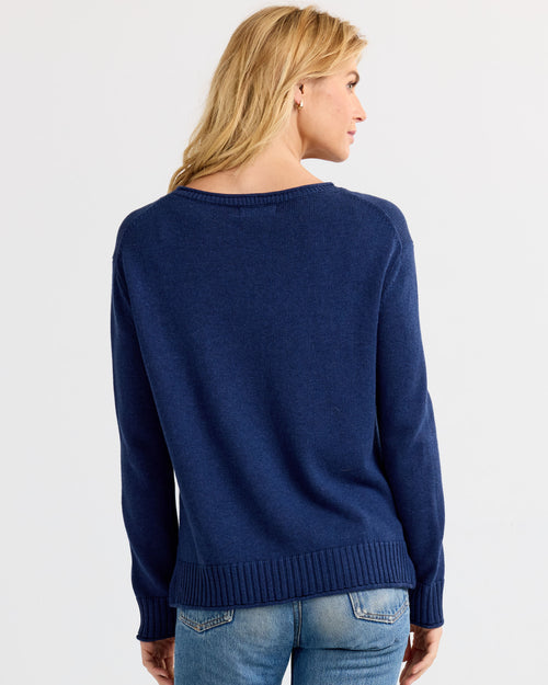 LIFESTYLE / EDITORIAL: Woman wearing navy blue cashmere sweater and jeans, shown from back against white background