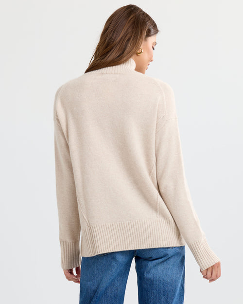 Oatmeal cashmere funnel neck sweater with blue jeans, back view