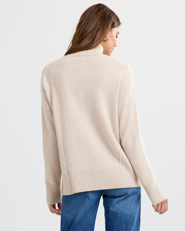 Oatmeal cashmere funnel neck sweater with blue jeans, back view