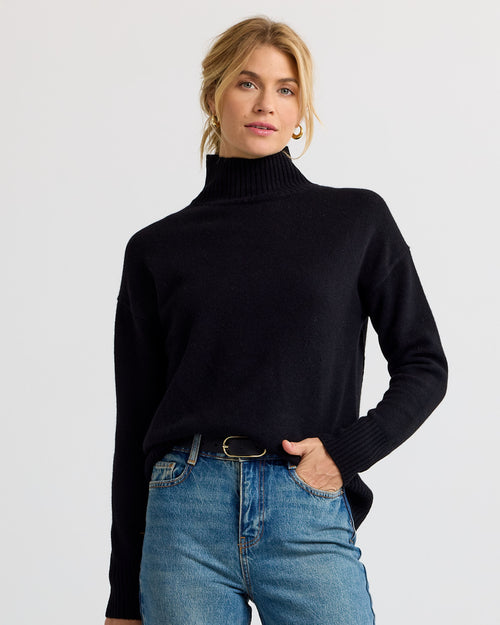 Black cashmere funnel neck sweater with blue jeans, front view