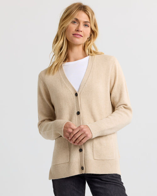 LIFESTYLE / EDITORIAL: Woman wearing sandstone beige cashmere cardigan over white top and black pants against white