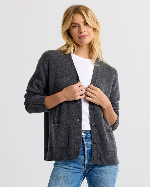 LIFESTYLE / EDITORIAL: Woman wearing charcoal gray cashmere cardigan over white shirt and blue jeans against white background