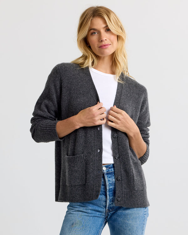 LIFESTYLE / EDITORIAL: Woman wearing charcoal gray cashmere cardigan over white shirt and blue jeans against white background