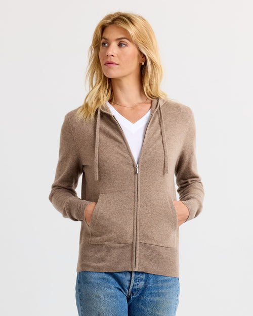 LIFESTYLE / EDITORIAL: Woman wearing driftwood-colored zip-up cashmere hoodie with pockets and white V-neck shirt