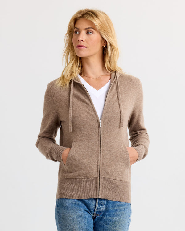 LIFESTYLE / EDITORIAL: Woman wearing driftwood-colored zip-up cashmere hoodie with pockets and white V-neck shirt