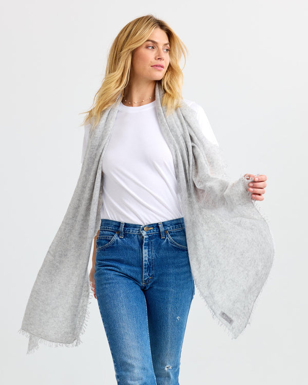 LIFESTYLE / EDITORIAL: Woman wearing light gray cashmere shawl over white tee and blue jeans against white background