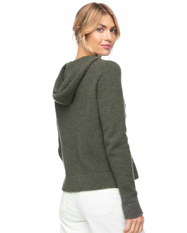 LIFESTYLE / EDITORIAL: Woman wearing dark olive cashmere fisherman hoodie with gray cuffs, viewed from back and side