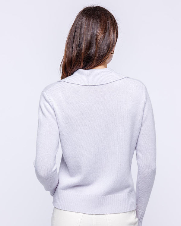 LIFESTYLE / EDITORIAL: Woman seen from back wearing lilac frost cashmere polo crew sweater against white background
