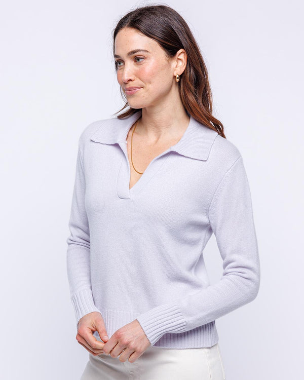 Woman wearing lilac frost cashmere polo crew sweater with collar and ribbed cuffs, standing against white background