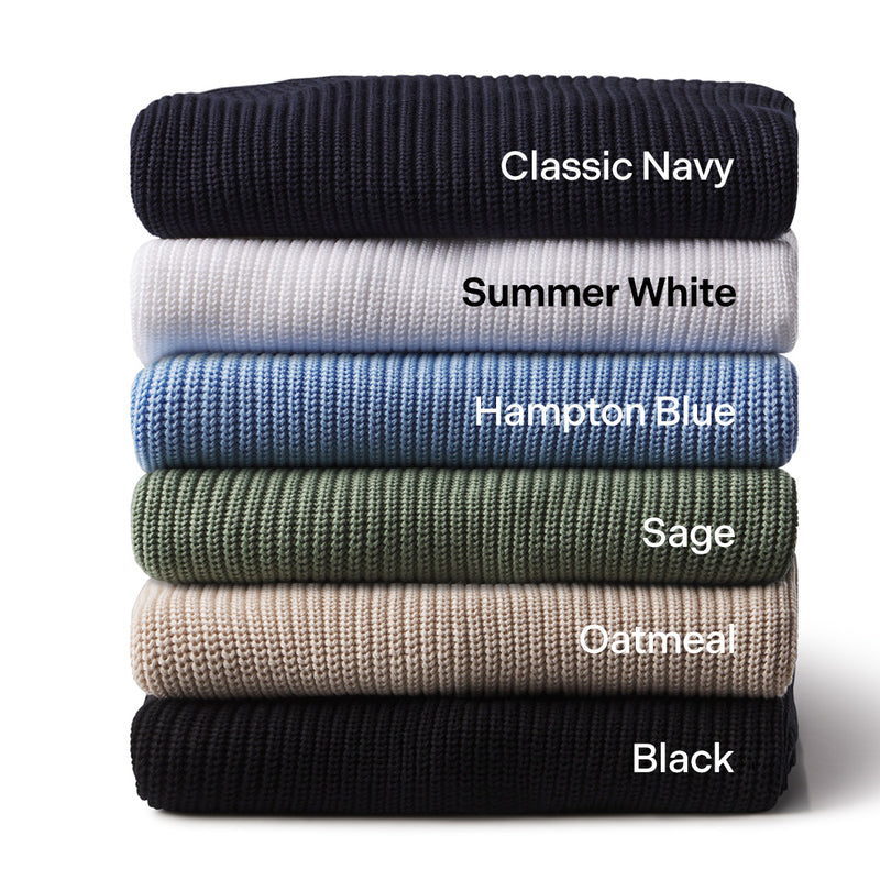 Stack of six folded cashmere sweaters in Classic Navy, Summer White, Hampton Blue, Sage, Oatmeal, and Black colors.