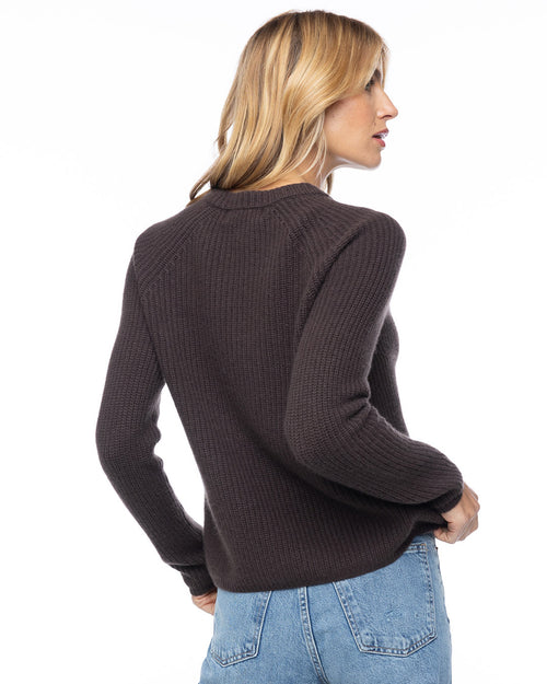 Side profile image of a woman wearing a dark chocolate ribbed cashmere sweater with light blue jeans