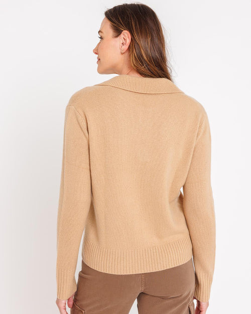LIFESTYLE / EDITORIAL: Woman wearing camel-colored cashmere sweater, shown from back against white background