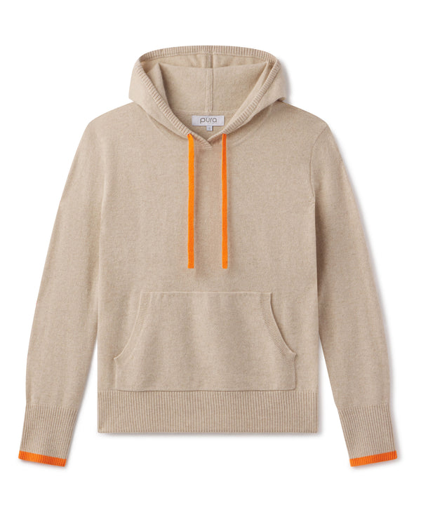 LIFESTYLE / EDITORIAL: Beige cashmere hoodie with orange drawstrings and cuff accents, laid flat on white background