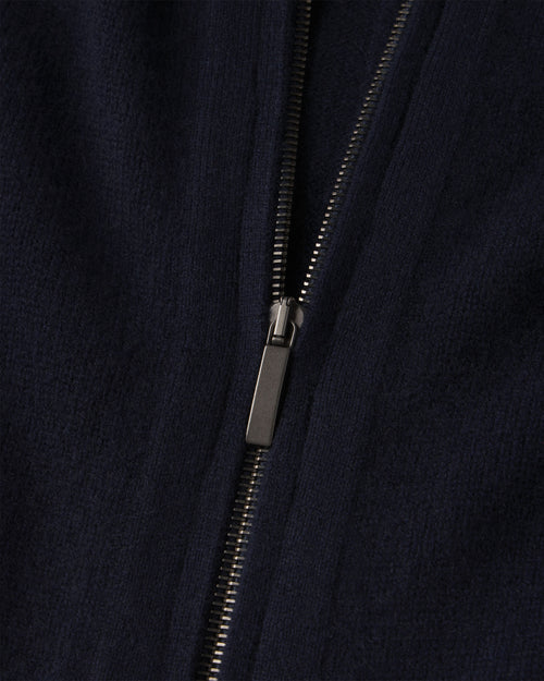 Close-up of navy blue cashmere fabric with black metal zipper on zip-up cardigan