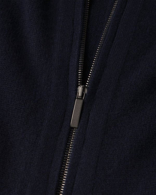 Close-up of navy blue cashmere fabric with black metal zipper on zip-up cardigan