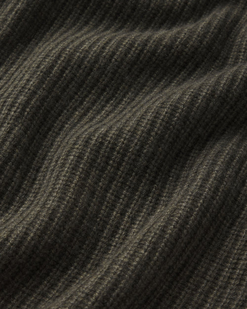 Close-up of dark olive ribbed cashmere fabric texture with soft folds