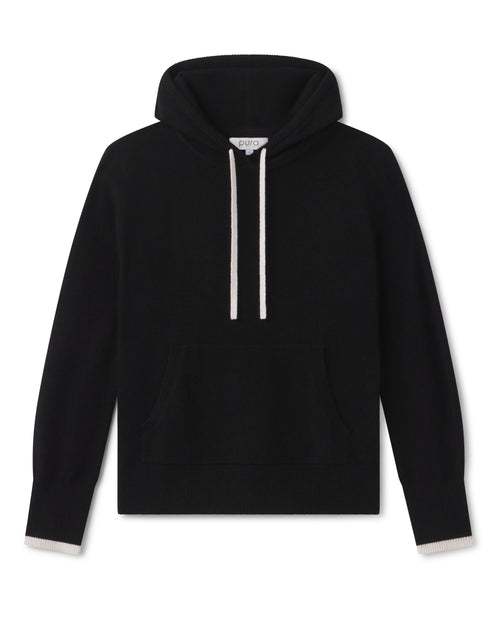 Black cashmere hoodie with ivory drawstrings and ivory trim on cuffs, front kangaroo pocket, laid flat on white background