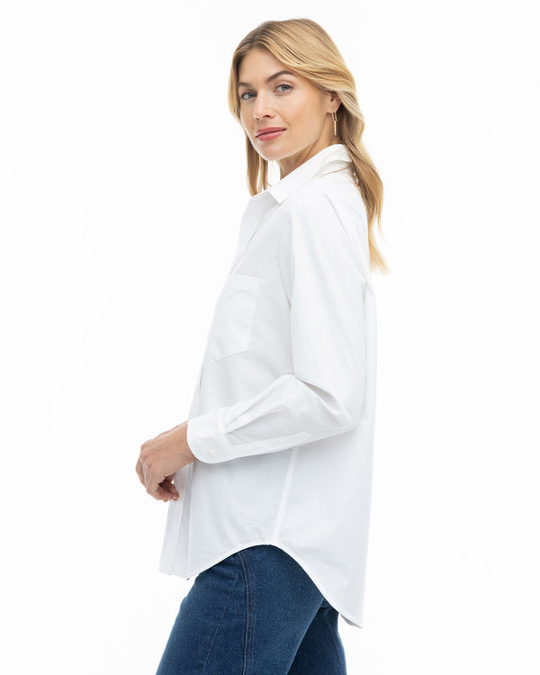 Woman in white button-up shirt and blue jeans, side view, against white background