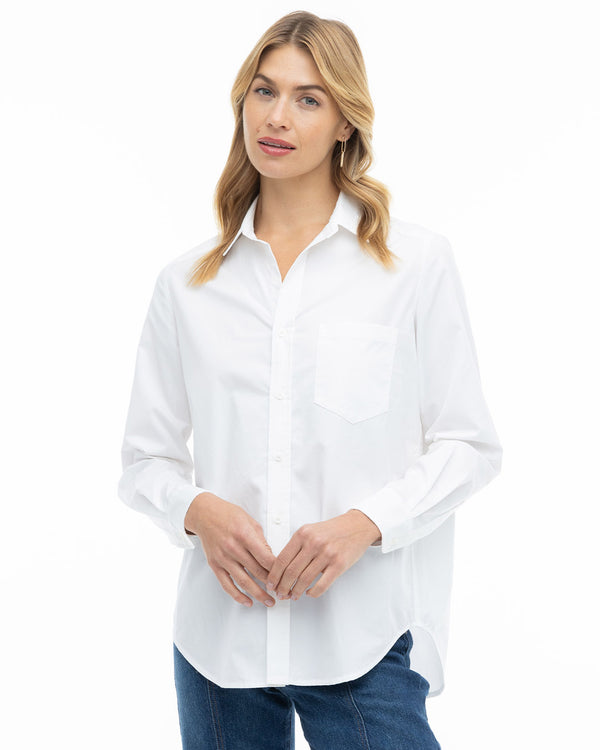 LIFESTYLE / EDITORIAL: Woman wearing a white button-up shirt and blue jeans against a white background