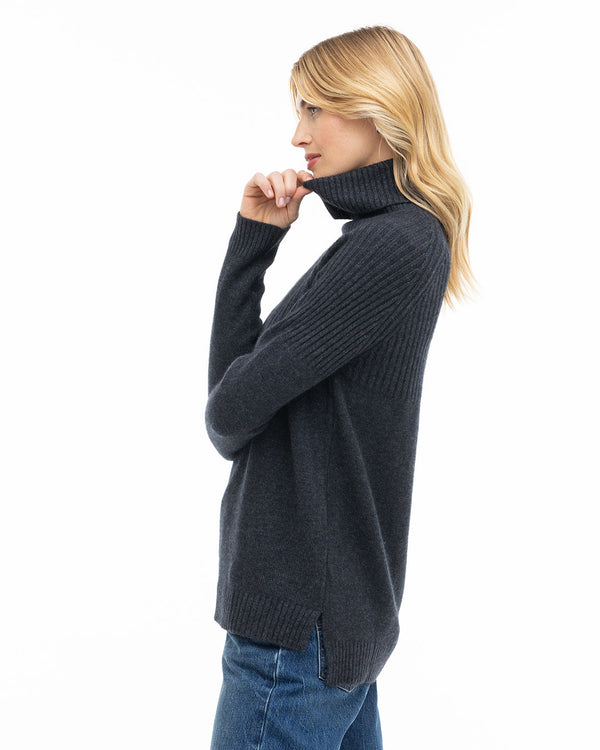 LIFESTYLE / EDITORIAL: Woman in charcoal turtleneck cashmere sweater and jeans, side profile on white background