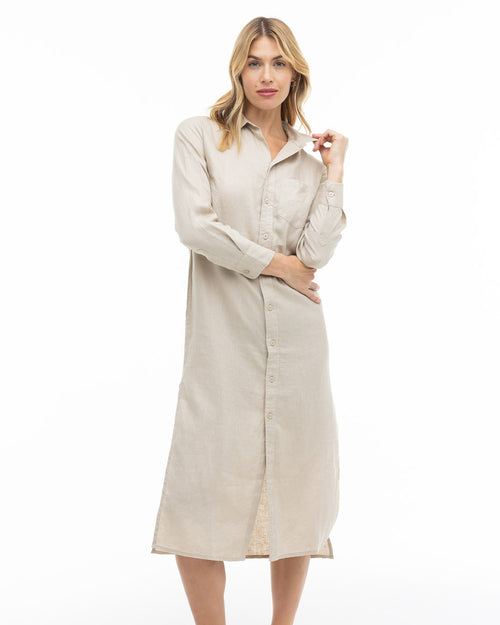Woman wearing long sandstone-colored button-up shirt dress with collar, standing against white background