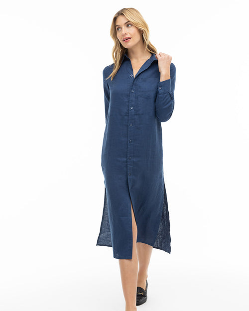 LIFESTYLE / EDITORIAL: Woman wearing navy blue long button-up shirt dress with long sleeves and black loafers walking forward
