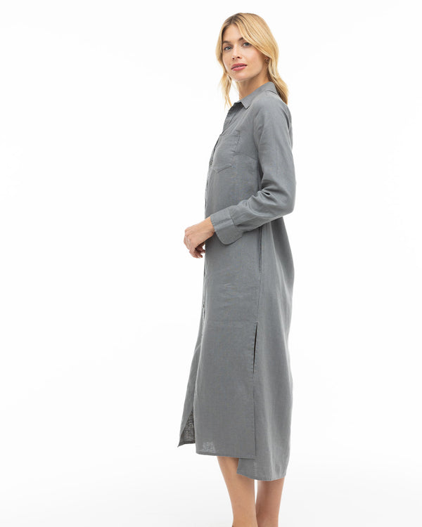 LIFESTYLE / EDITORIAL: Woman in long gray shirt dress standing sideways against white background