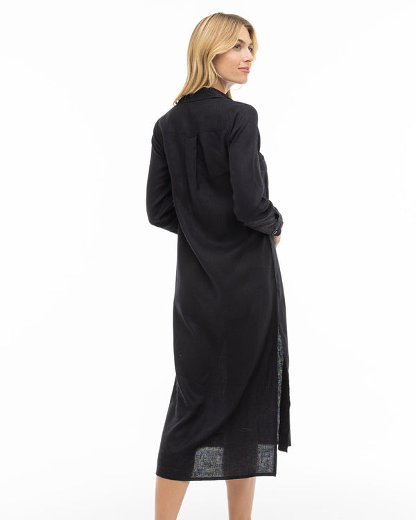 LIFESTYLE / EDITORIAL: Woman wearing long black cashmere dress, standing and looking over her shoulder against white