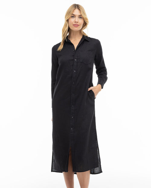 LIFESTYLE / EDITORIAL: Woman wearing long black button-up shirt dress with collar and pockets, standing against white