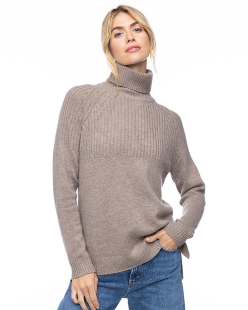 Front three-quarter view image of a woman wearing a vintage khaki half-rib turtleneck cashmere sweater with blue jeans