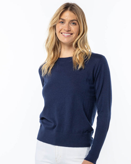 LIFESTYLE / EDITORIAL: Woman wearing navy blue cashmere sweater, smiling against white background