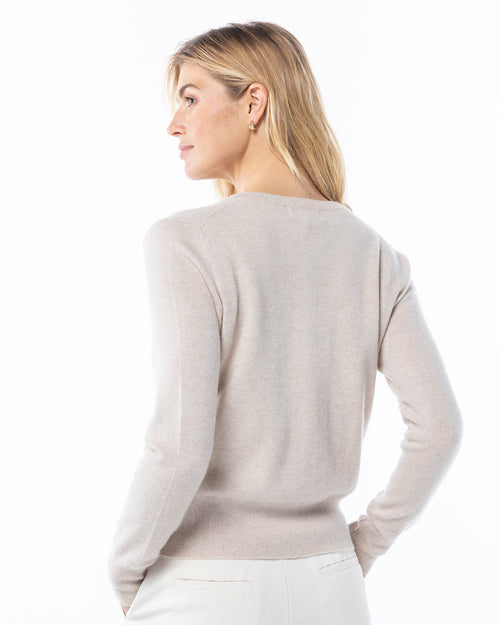 LIFESTYLE / EDITORIAL: Woman wearing oatmeal-colored cashmere sweater, facing sideways with hands in pockets