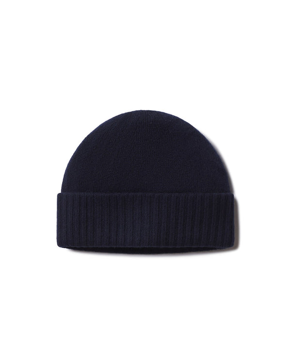 Cashmere knit navy blue beanie hat with folded ribbed cuff, isolated on white background