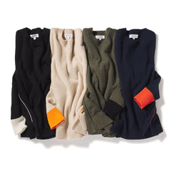 Four folded cashmere sweaters in black, beige, olive, and navy with contrasting cuff details on white background